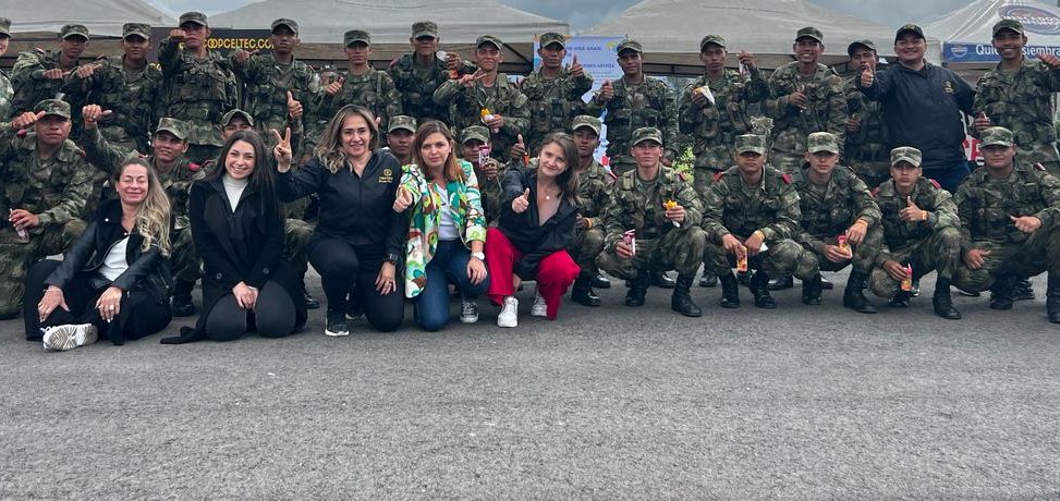 Asociados en una charla de COOPCELTEC junto al pendón institucional