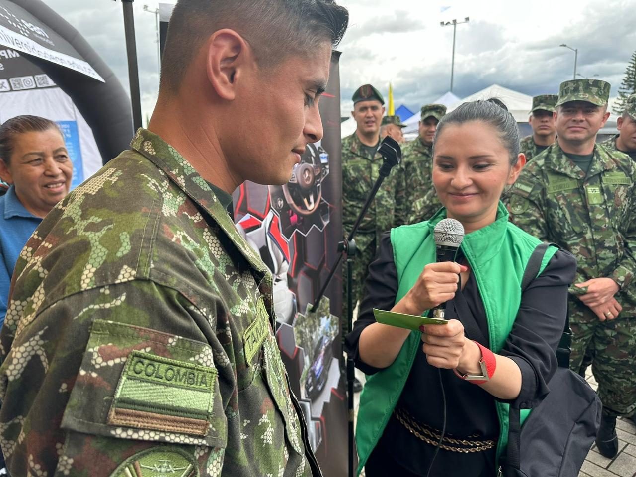 Asesora de COOPCELTEC conversando con un soldado en una jornada de crédito